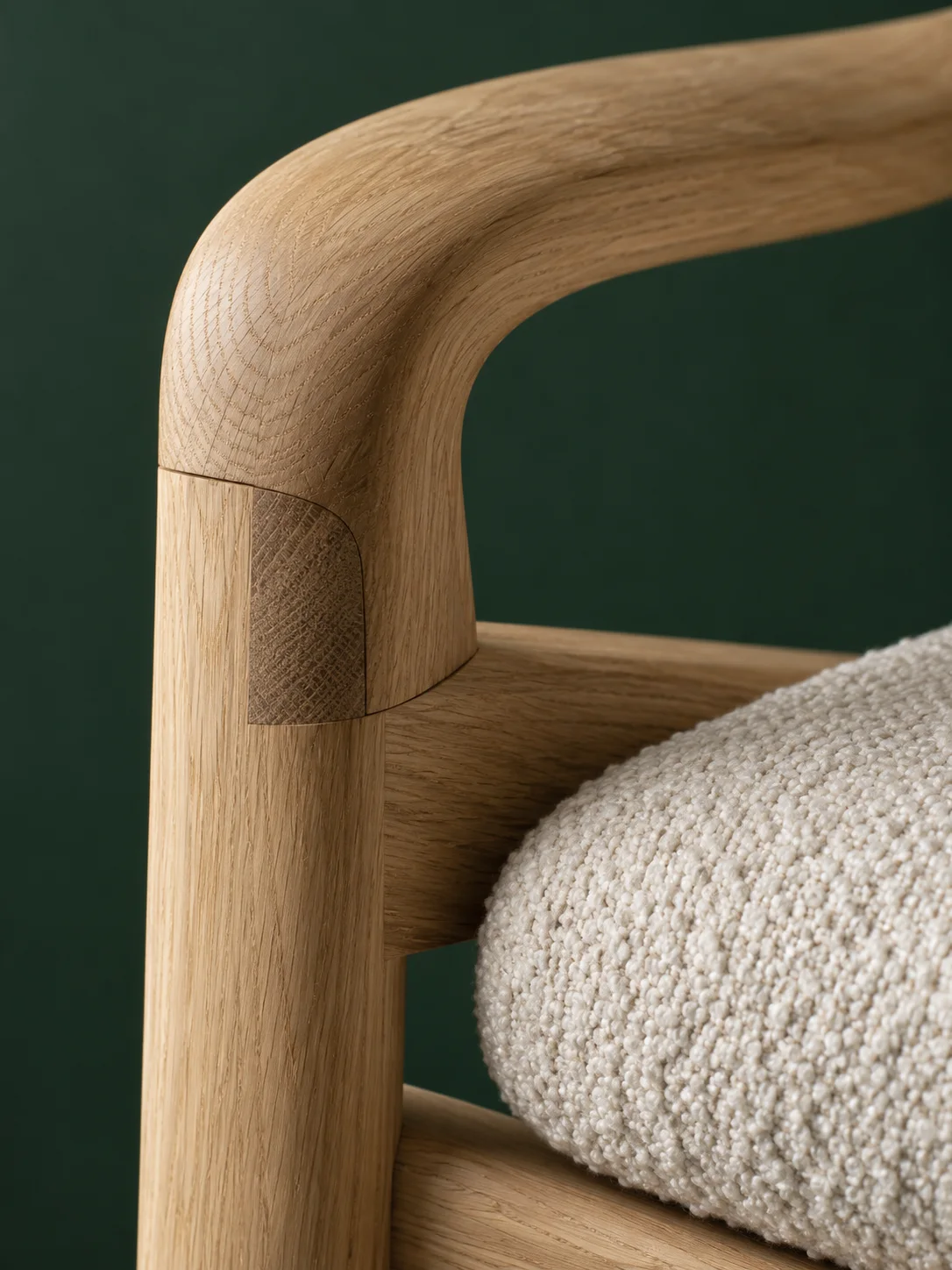 Close detail of an oak chair frame and textured light upholstery